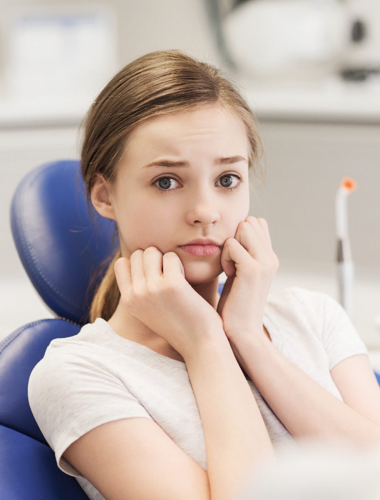 people, medicine, stomatology and phobia concept - scared and terrified patient girl at dental clinic office