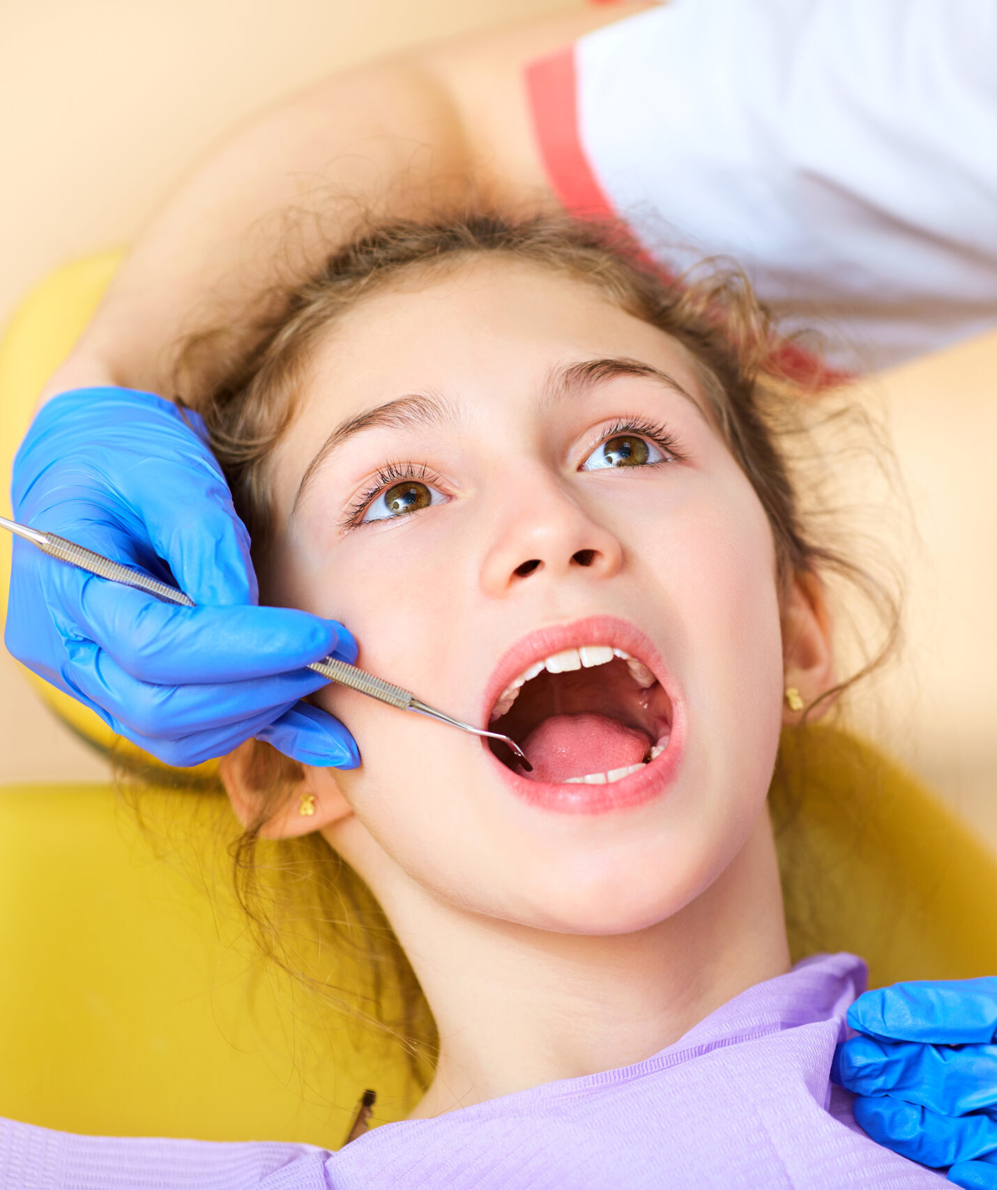 Woman dentist treats your child's teeth in the dental office.