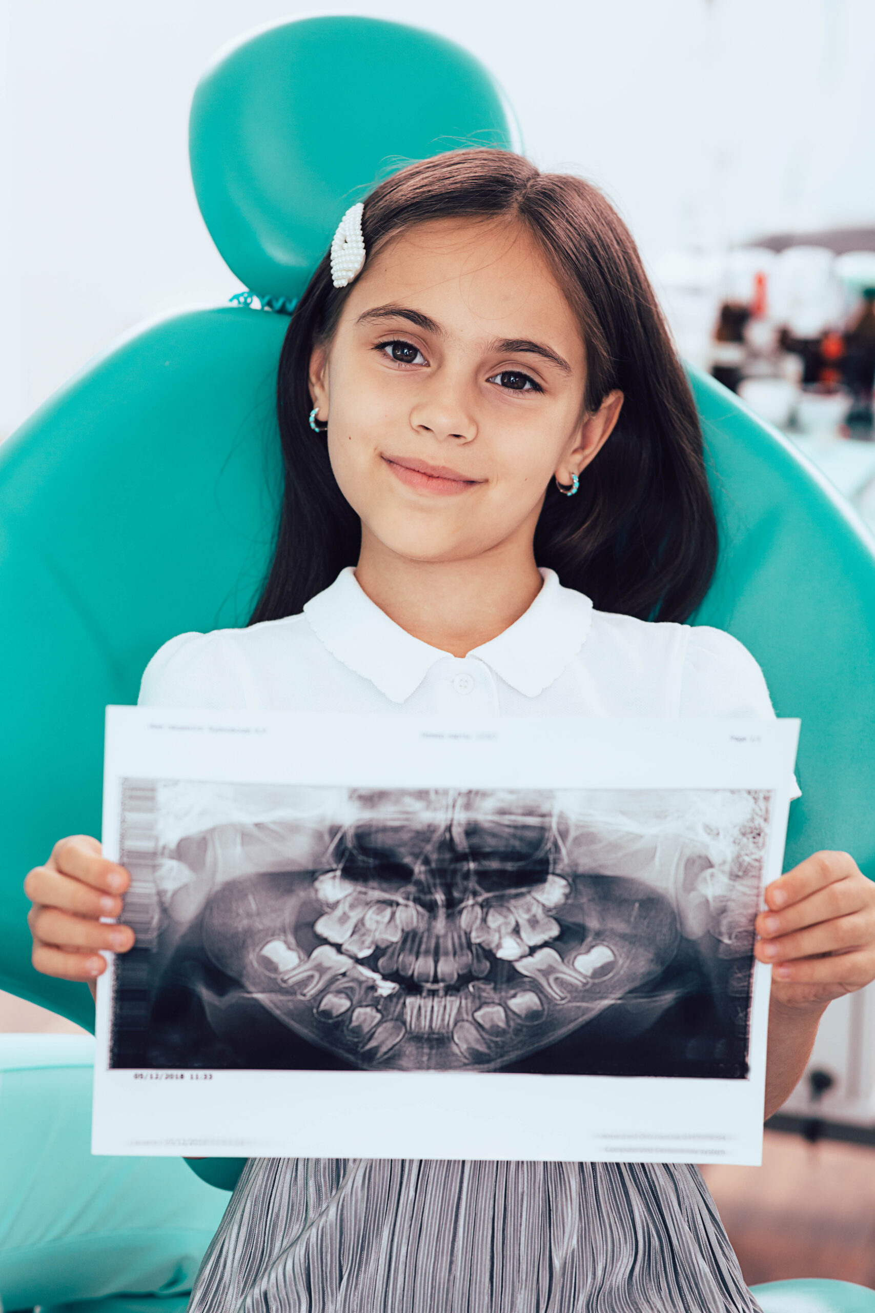 mixed race little girl showing her x-ray teeth picture. Pediatric dentistry