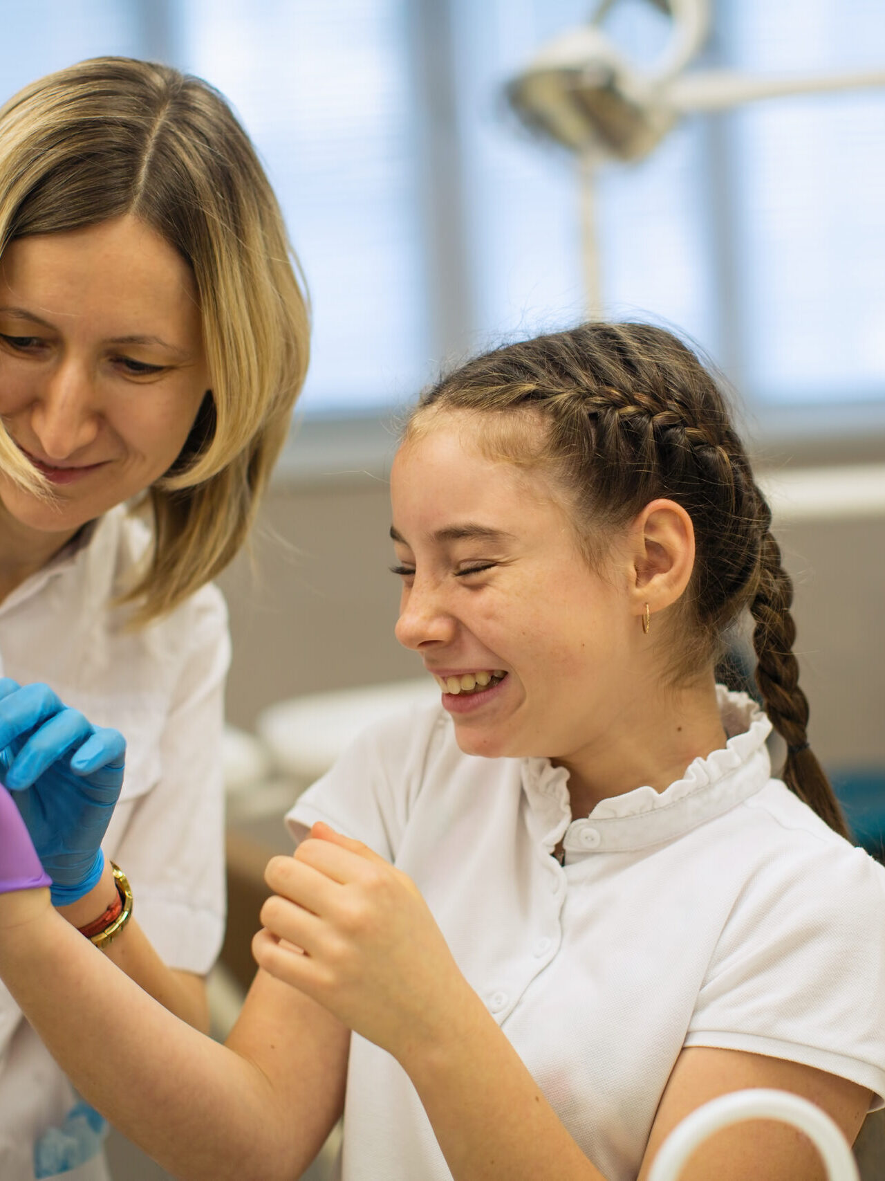 Teen girl with the help of dentist wear medical gloves.