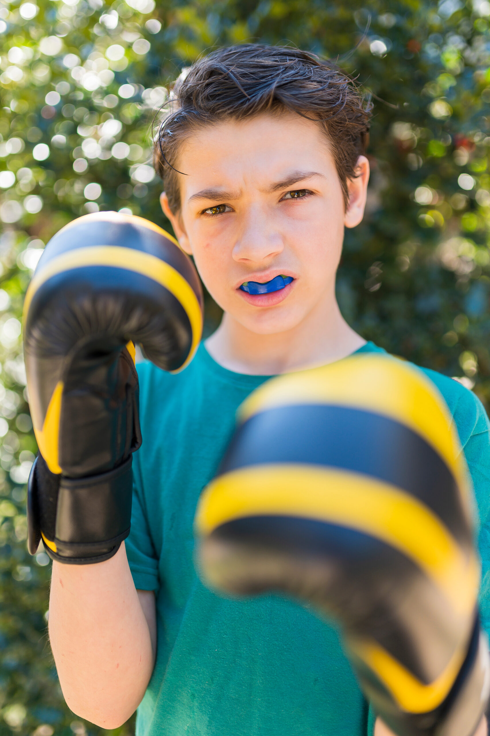 Boy practicing boxing outdoors.