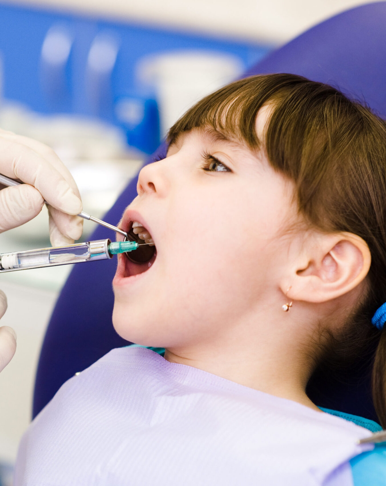 dentist holding a syringe and anesthetizing his patient