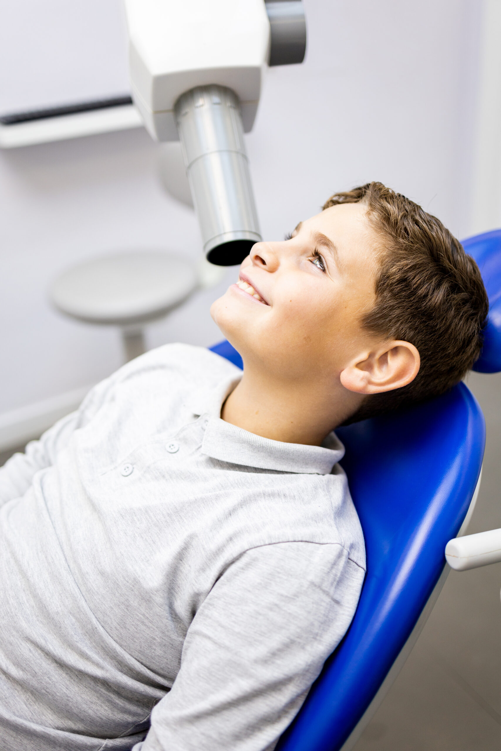 A Caucasian boy between 9 and 10 years old visits a dentist clinic to have an intraoral x-ray to identify cases of cavities,Intraoral x-ray concept.
