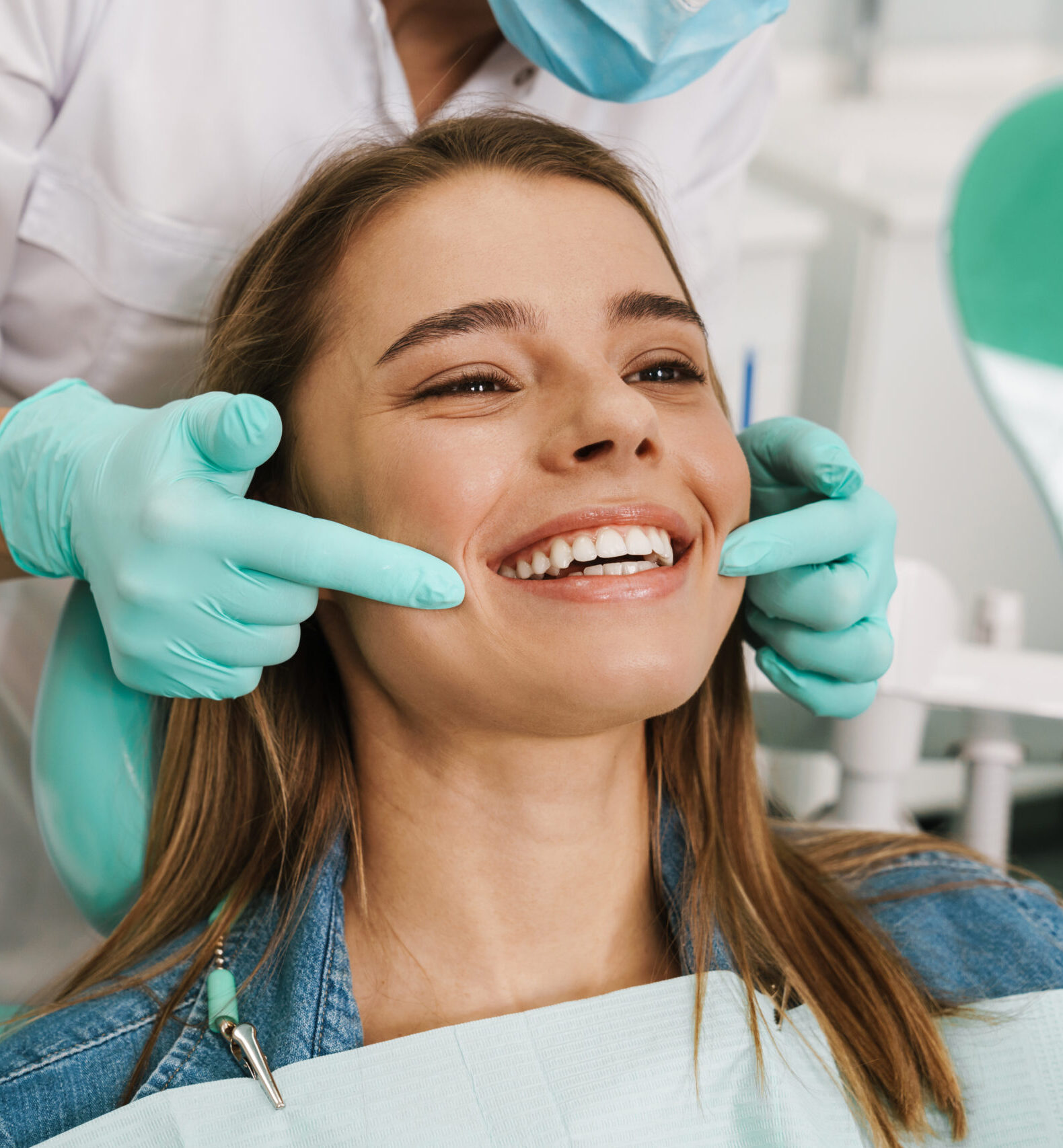 European young woman smiling while looking at mirror in dental clinic