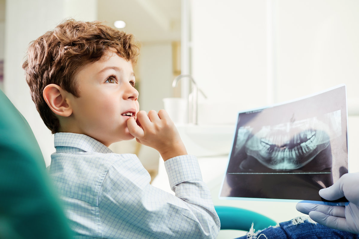 Boy child looks at x heaven image in the dentist's office.