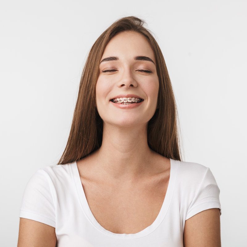 Attractive young woman standing isolated over white background, laughing